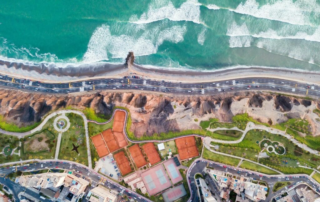 Vista aérea de la Costa Verde en Lima, destacando el encuentro entre la ciudad y el mar, ofrecido en los tours personalizados de Perú Atractivo.