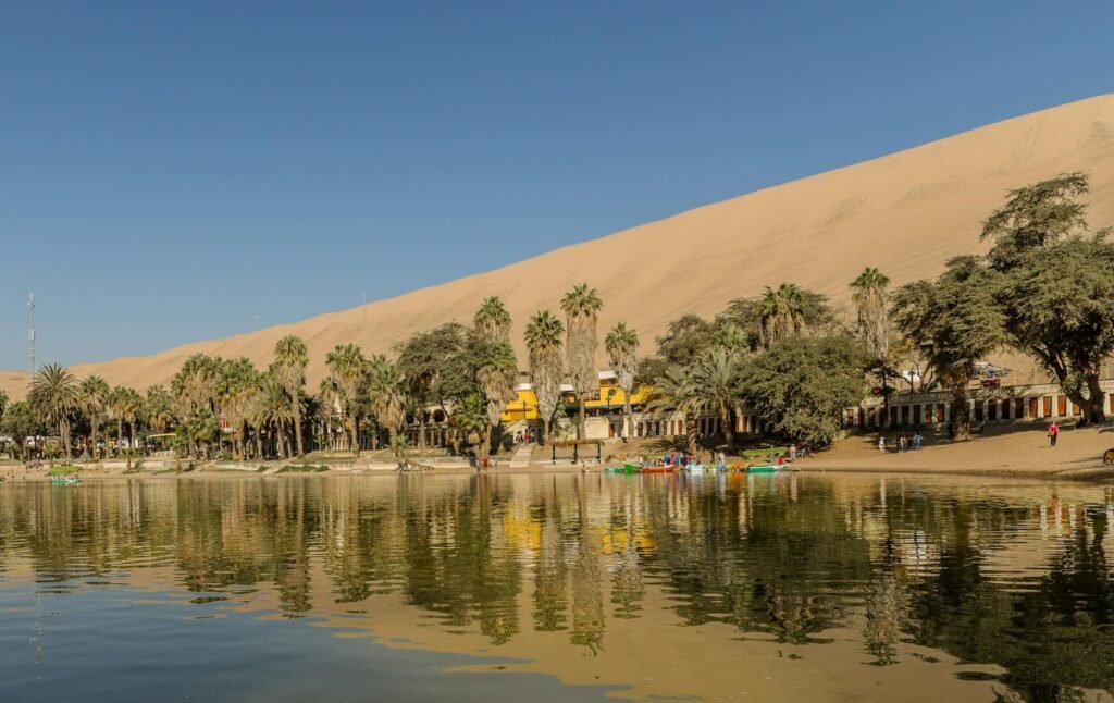 Vista del oasis de Huacachina rodeado de dunas, una experiencia personalizada de slow travel ofrecida por Perú Atractivo.