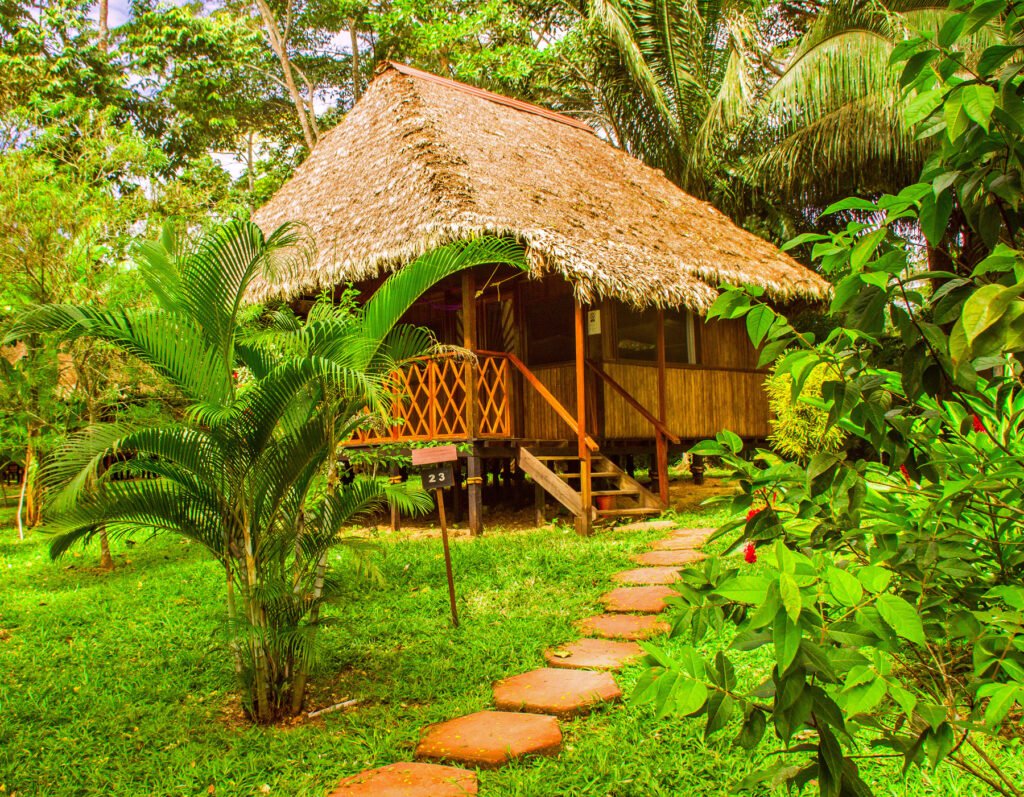 Cabaña amazónica tradicional del Corto Maltes Lodge en Puerto Maldonado con techo de paja y arquitectura sostenible