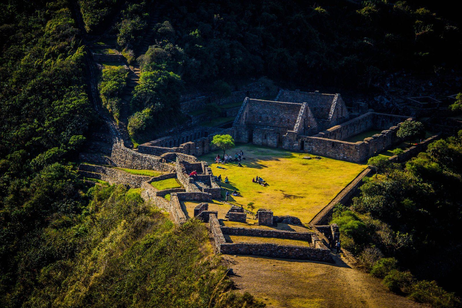 Vista aérea del complejo arqueológico de Choquequirao con sus plazas ceremoniales, recintos de piedra y terrazas agrícolas rodeadas de exuberante vegetación andina
