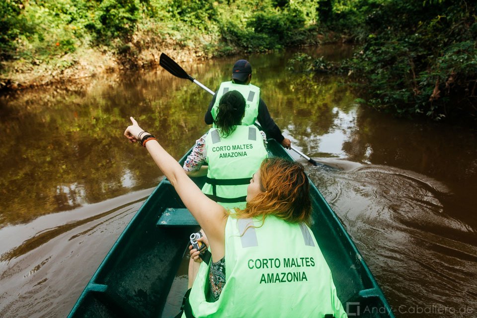 Turistas navegando en canoa por río amazónico con guía local en excursión desde Corto Maltes Lodge