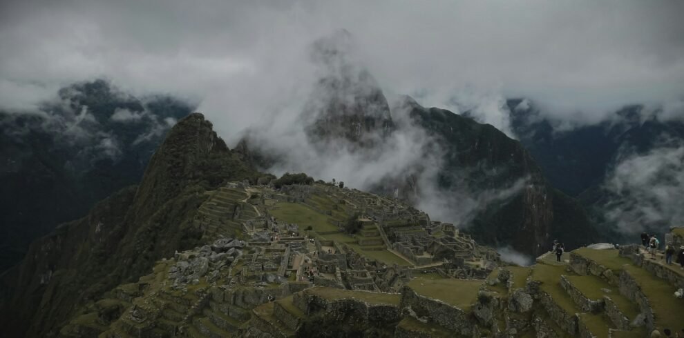 Machu Picchu envuelto en niebla matutina con turistas explorando