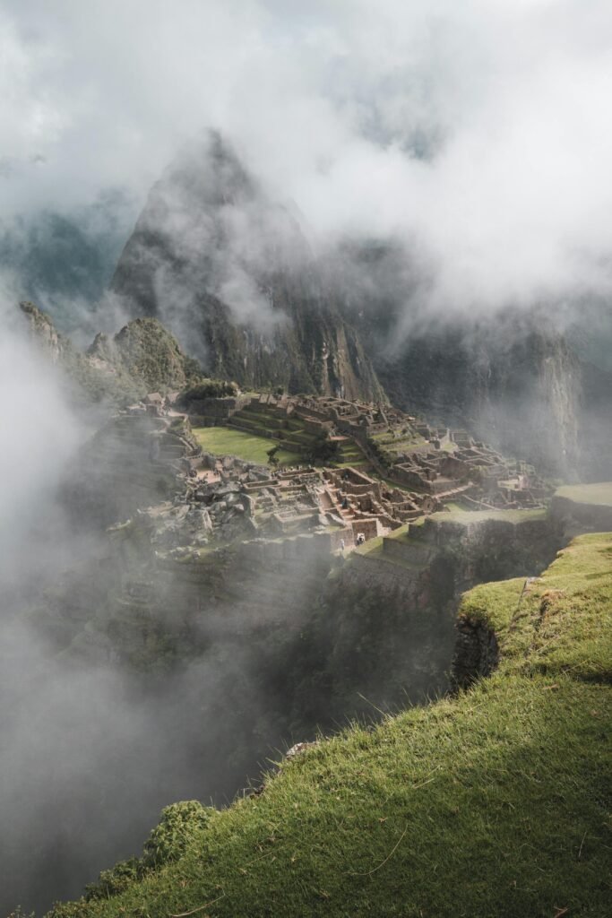 Vista panorámica de las ruinas de Machu Picchu y Huayna Picchu bajo cielo nublado
