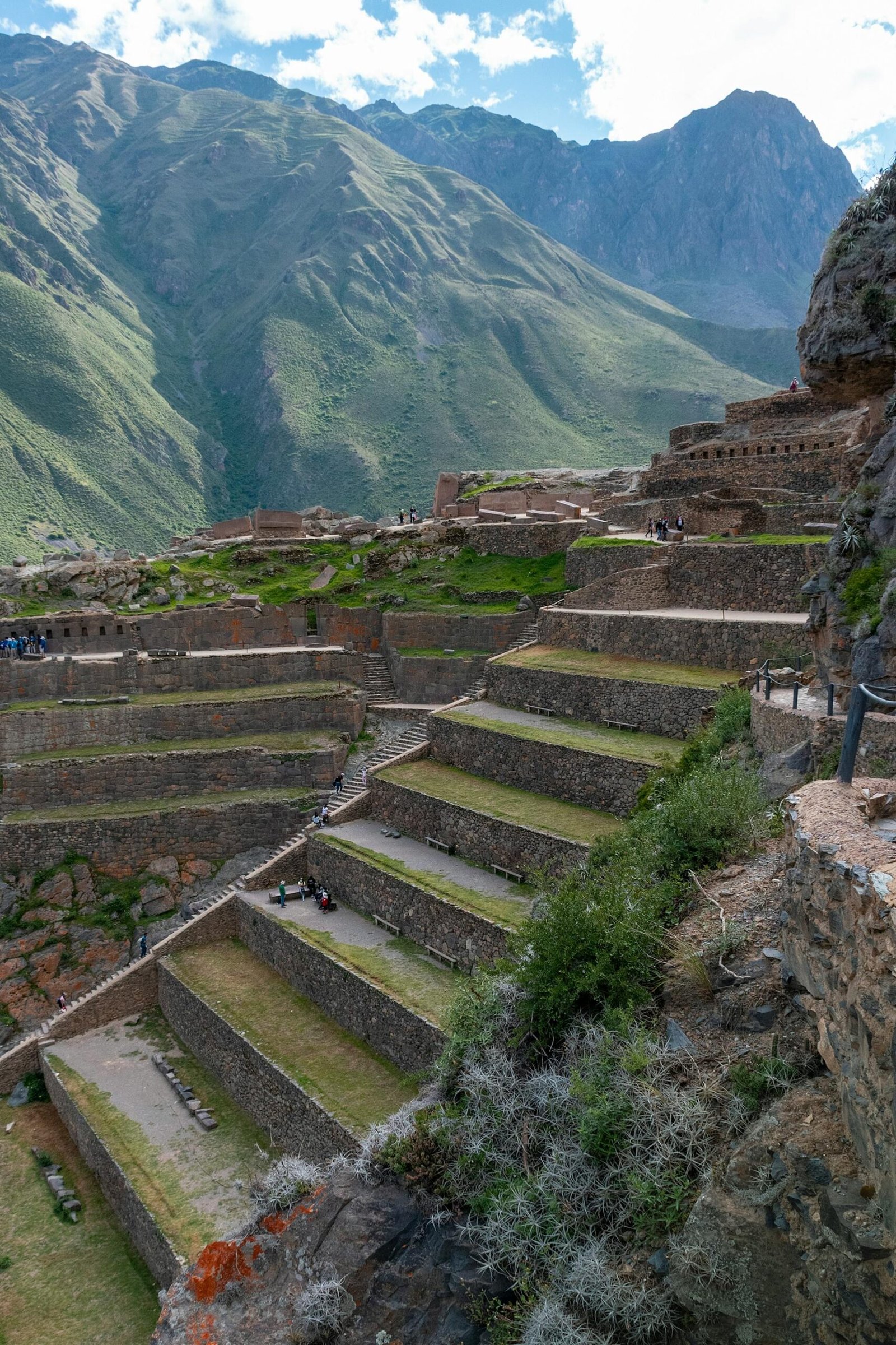 Terrazas y estructuras arqueológicas incas con imponentes montañas andinas al fondo en Ollantaytambo