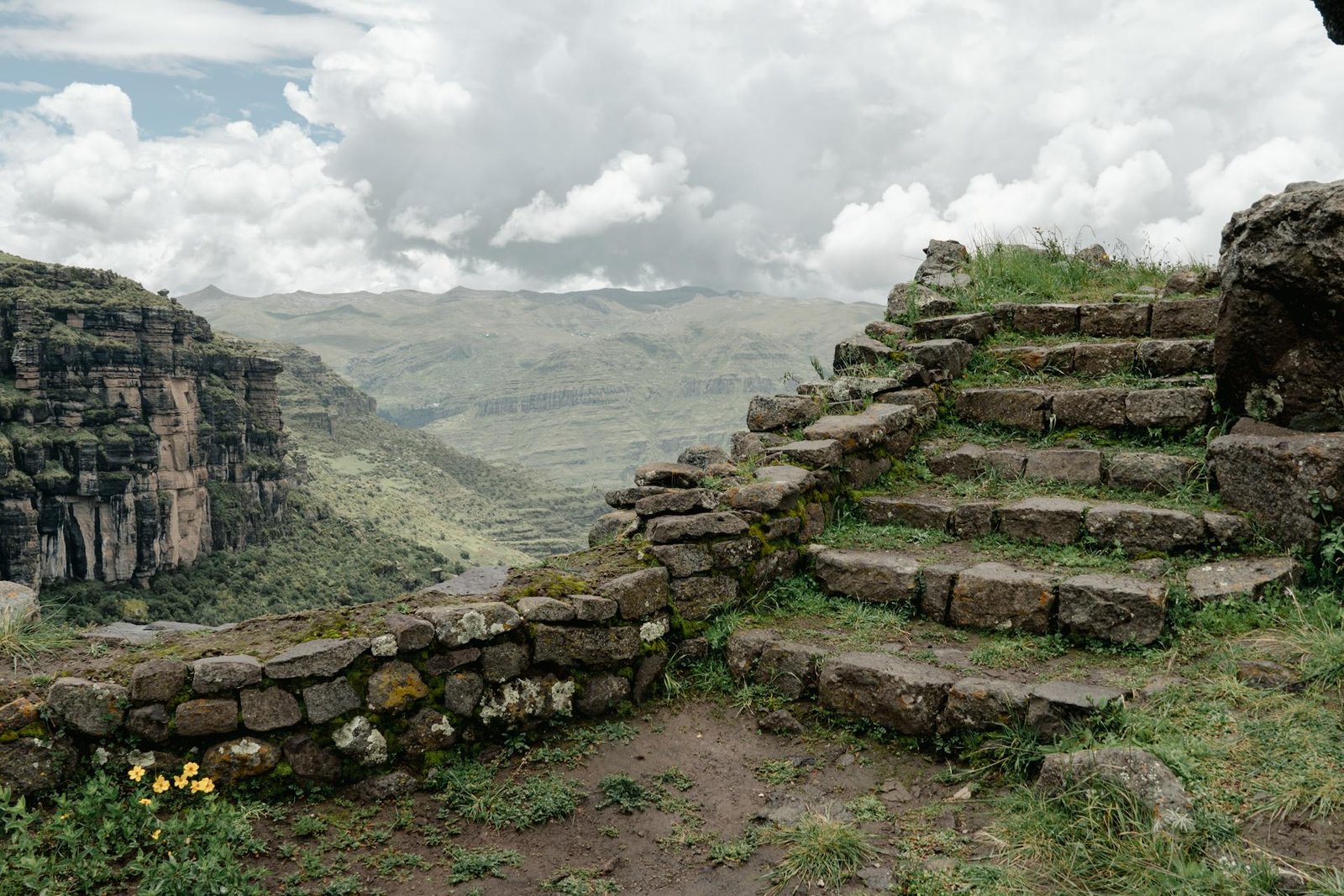 Escaleras de piedra inca en Waqrapukara con vista panorámica al valle y montañas andinas