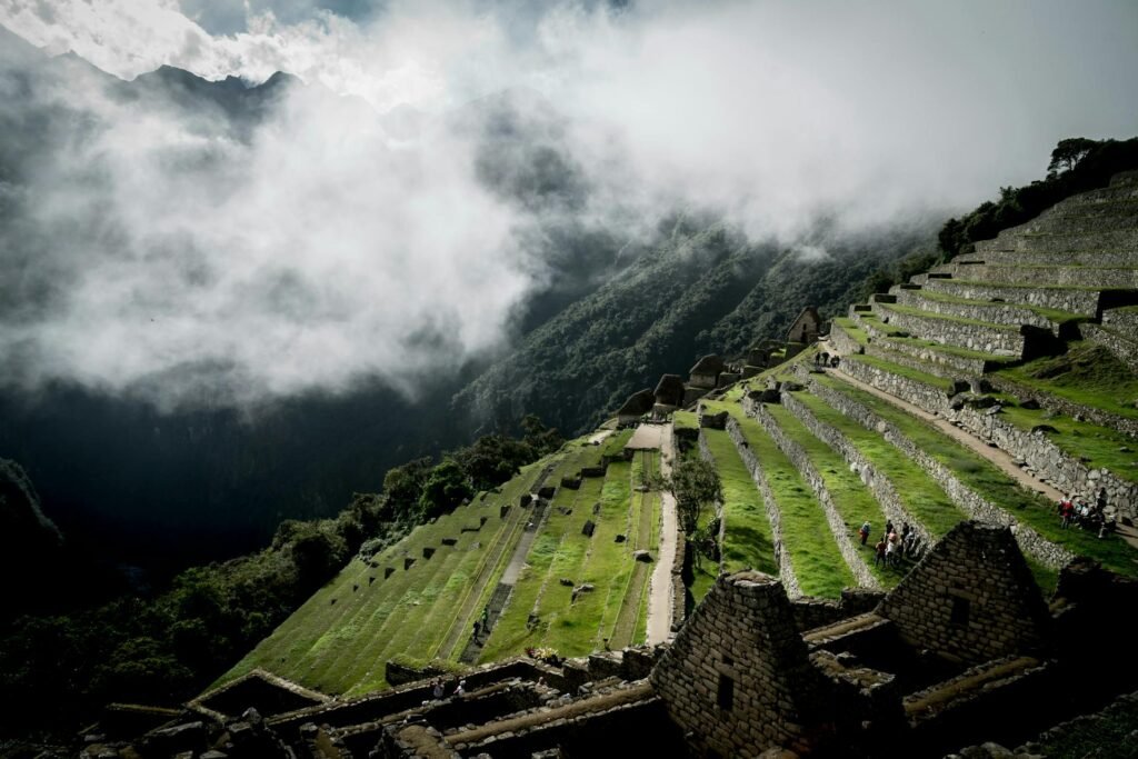 Vista aérea de Machu Picchu con montañas y nubes.